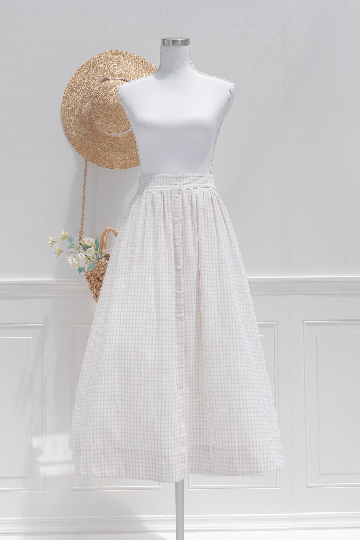 White check cotton midi skirt with half elasticized waistband and button front placket, front view.