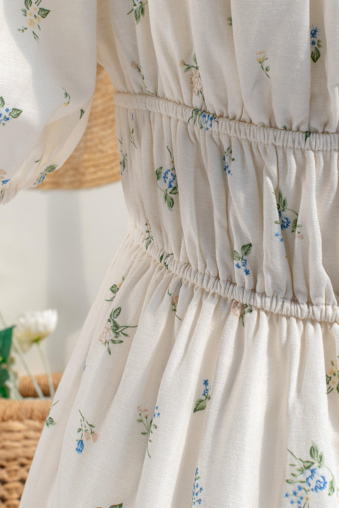 Cottagecore dress. A cute floral cottagecore style dress perfect for spring. Short sleeves, elastic bodice, square neckline, elastic shoulders. up close fabric view. Amantine. 