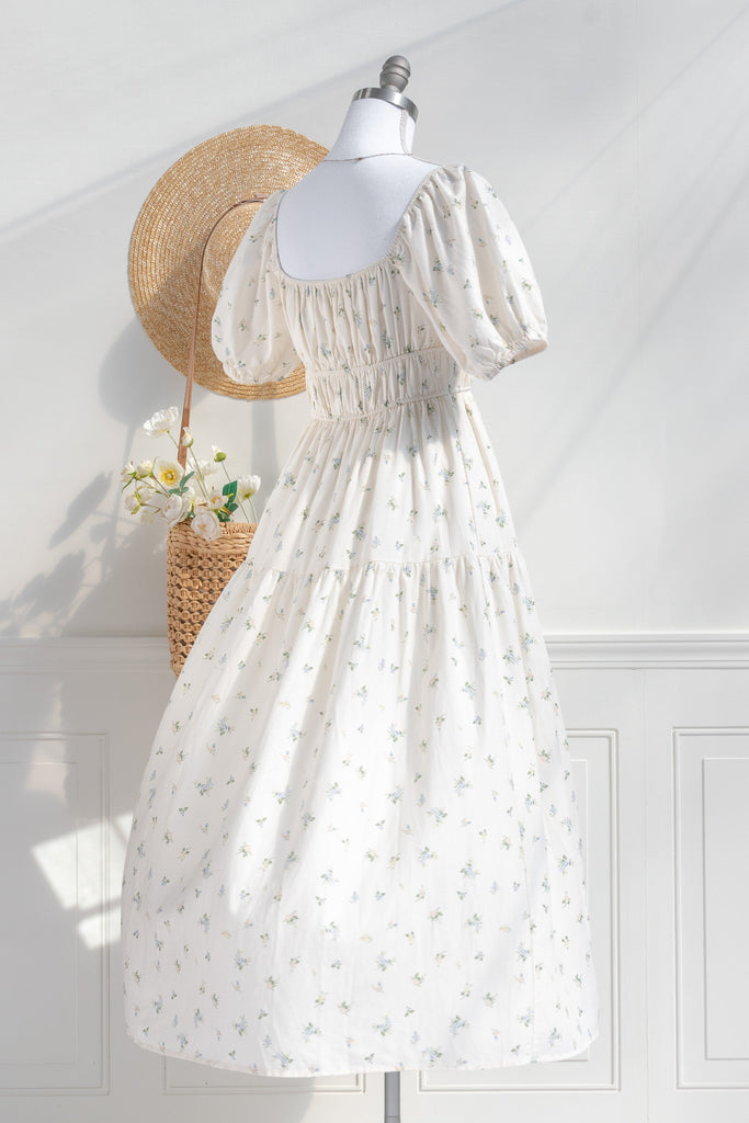 Cottagecore dress. A cute floral cottagecore style dress perfect for spring. Short sleeves, elastic bodice, square neckline, elastic shoulders. 3/4 back view. Amantine. 