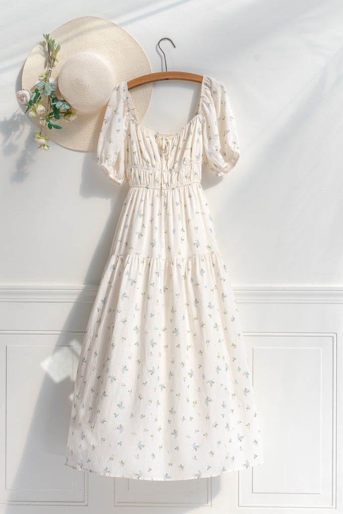 Cottagecore dress. A cute floral cottagecore style dress perfect for spring. Short sleeves, elastic bodice, square neckline, elastic shoulders. view of dress on hanger. Amantine. 