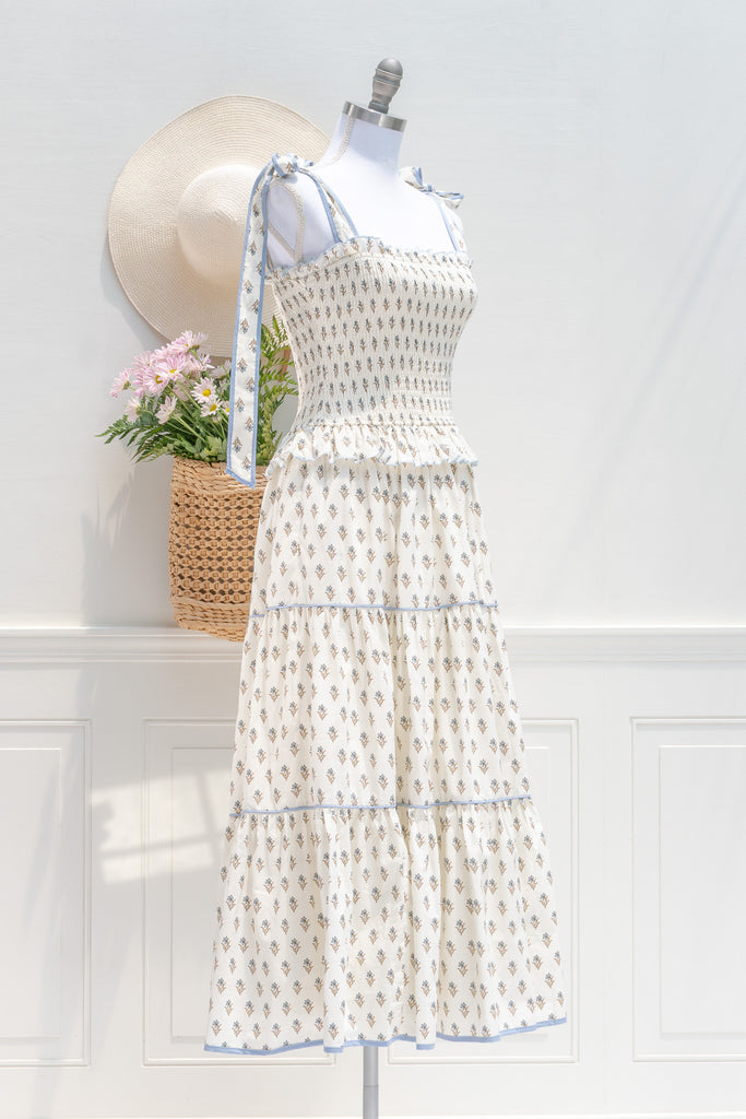 cotton floral summer dress with bow straps. cream floral with light blue trim. perfect romantic french girl style outfit idea. 3/4 side view. amantine dresses. 
