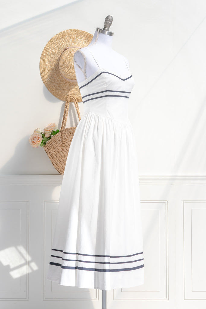 Side view of Amantine’s cottagecore nautical stripe dress, featuring elegant side stripes and flowing skirt, paired with a straw hat, ideal for a stylish look.