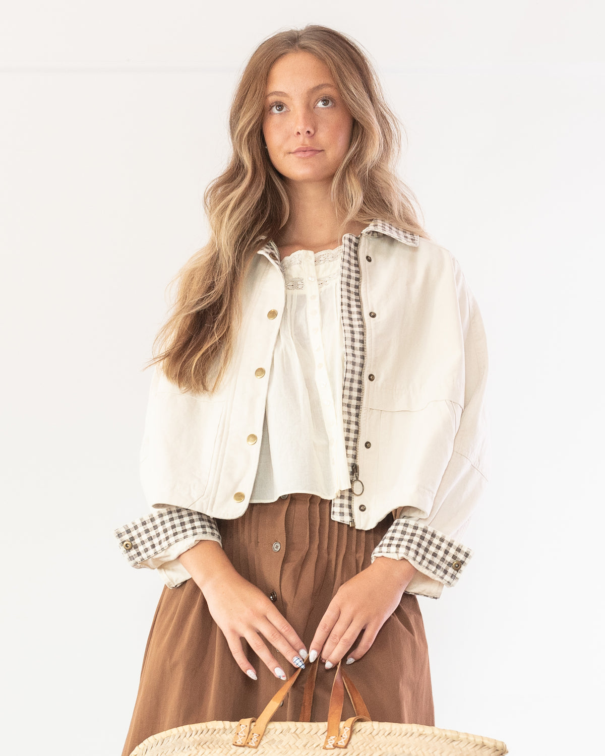 Cream cotton chore jacket worn open over a white top and brown skirt, model front view.