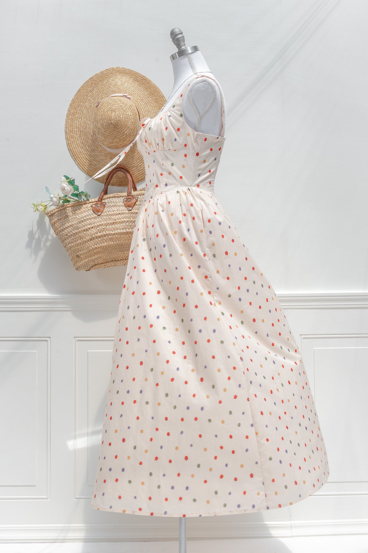Cream polka dot cotton midi dress with corset bodice structure and billowing skirt side view.