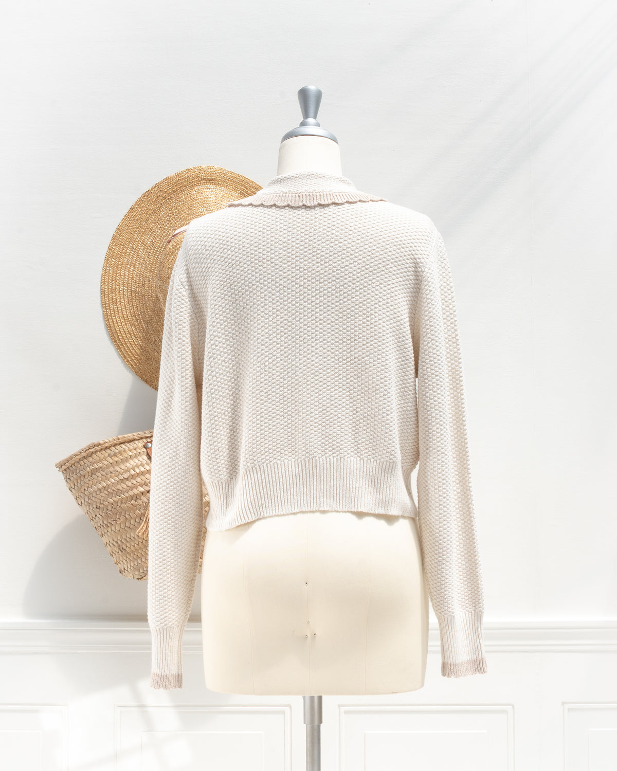 Ivory knit cardigan with cropped silhouette and ribbed hem, a feminine fall layer, mannequin back view.