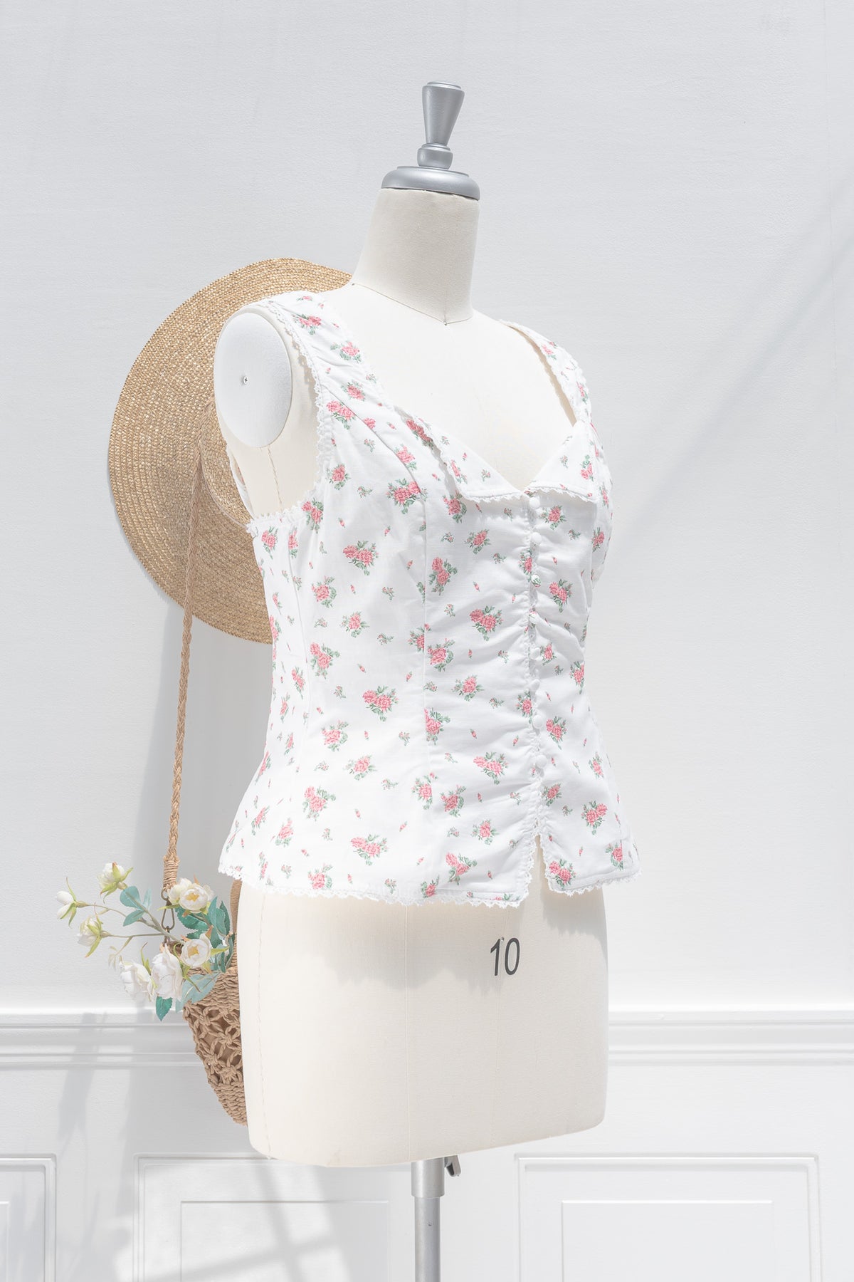 White floral linen cotton bustier top showing structured fit and button front detail, three quarter view.