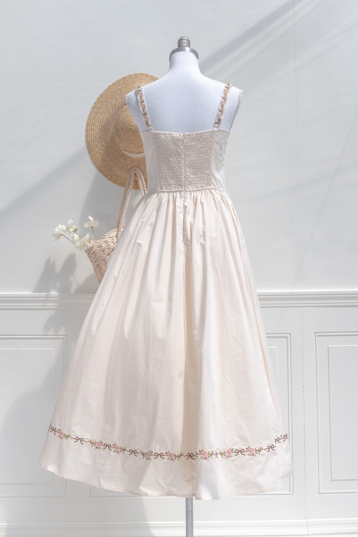 Romantic cream cotton midi dress with smocked elastic back and embroidered shoulder straps back view.