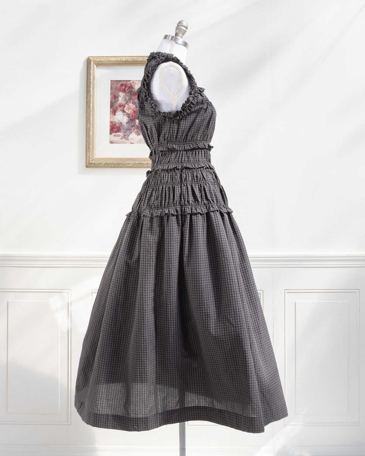 Gray plaid midi dress with full flowing skirt on a mannequin, feminine vintage inspired, side view.