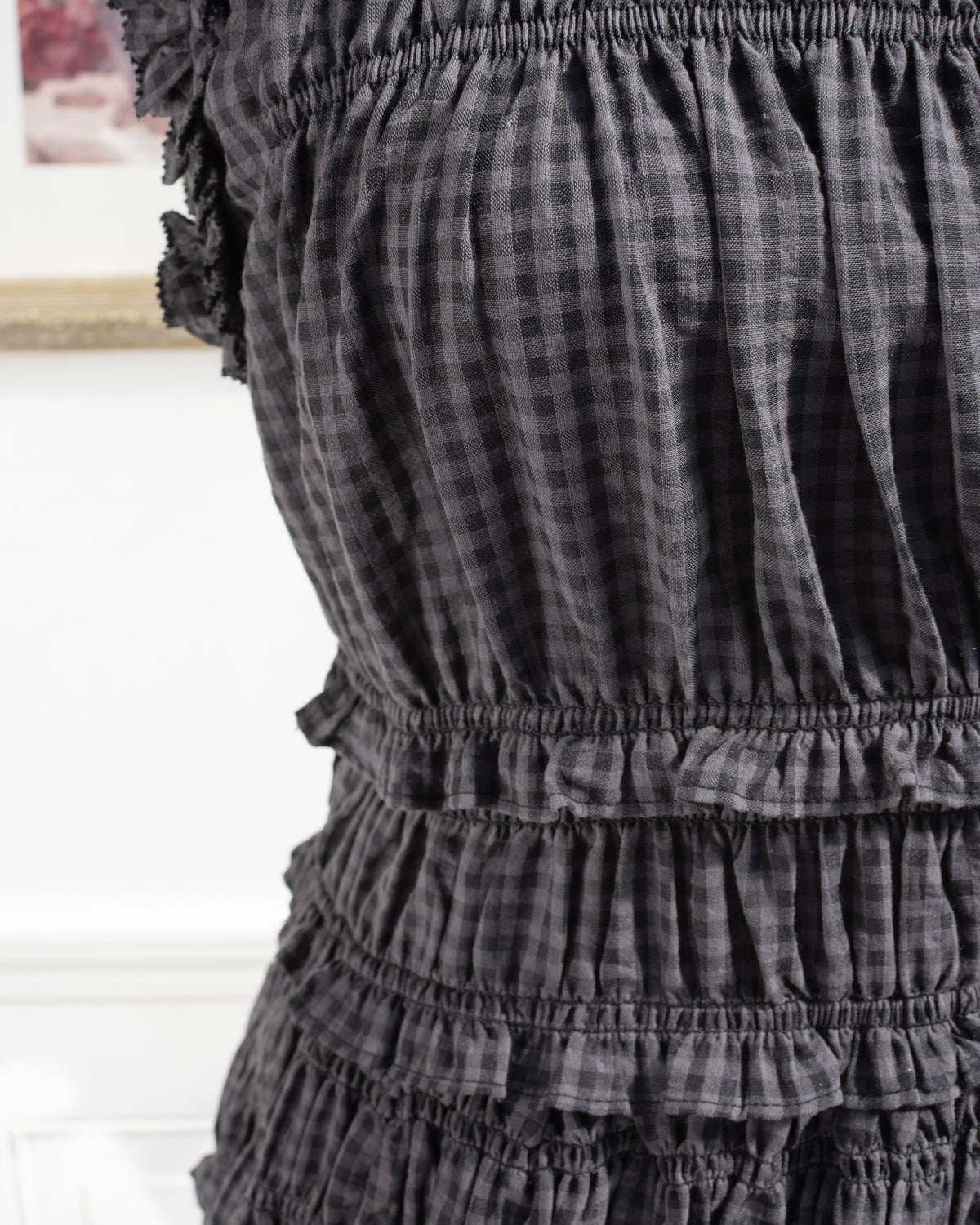 Gray plaid dress with ruffle trim and smocked bodice, feminine romantic French style, detail view.