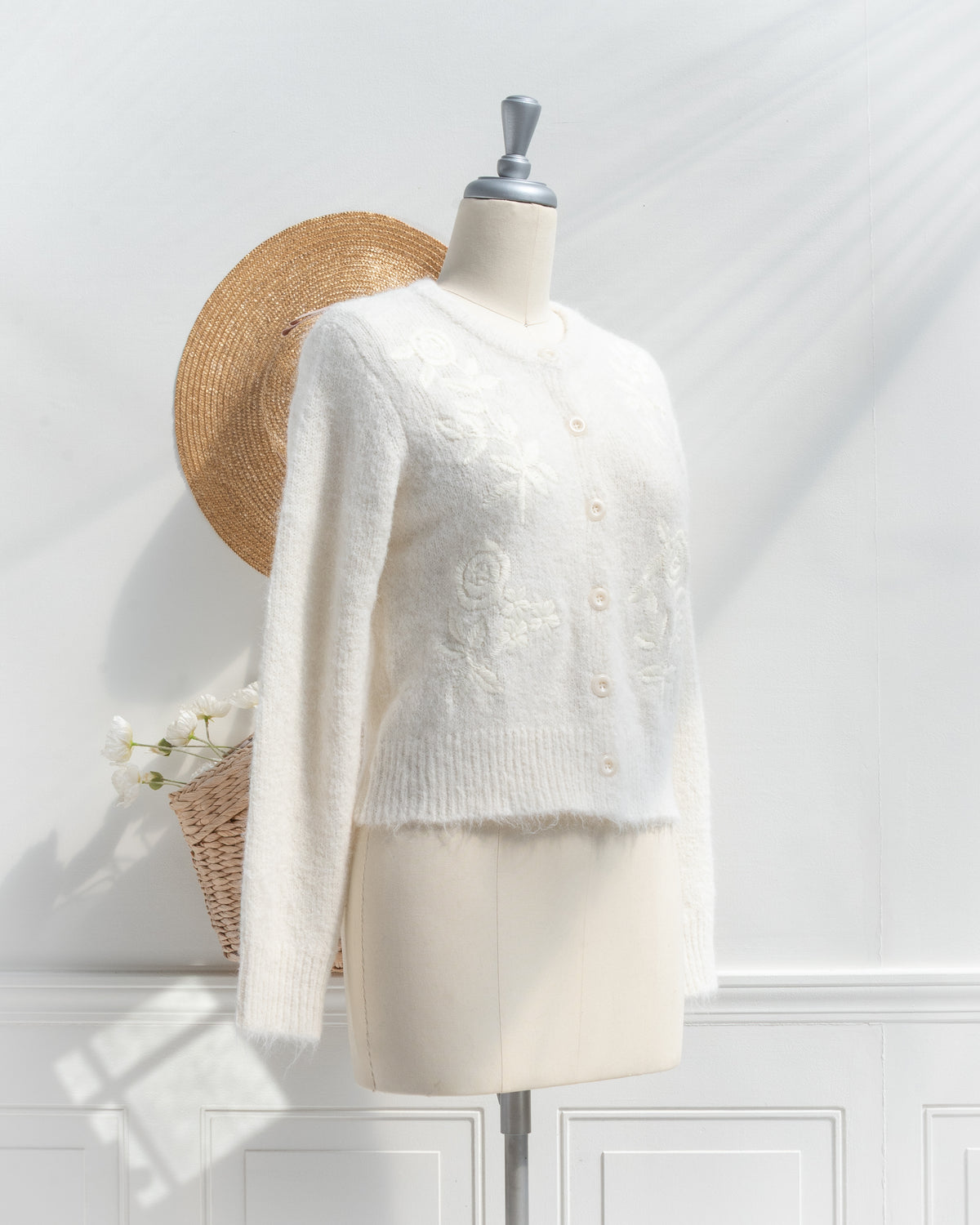 Ivory floral embroidered cardigan shown on a mannequin, three quarter view french girl style.