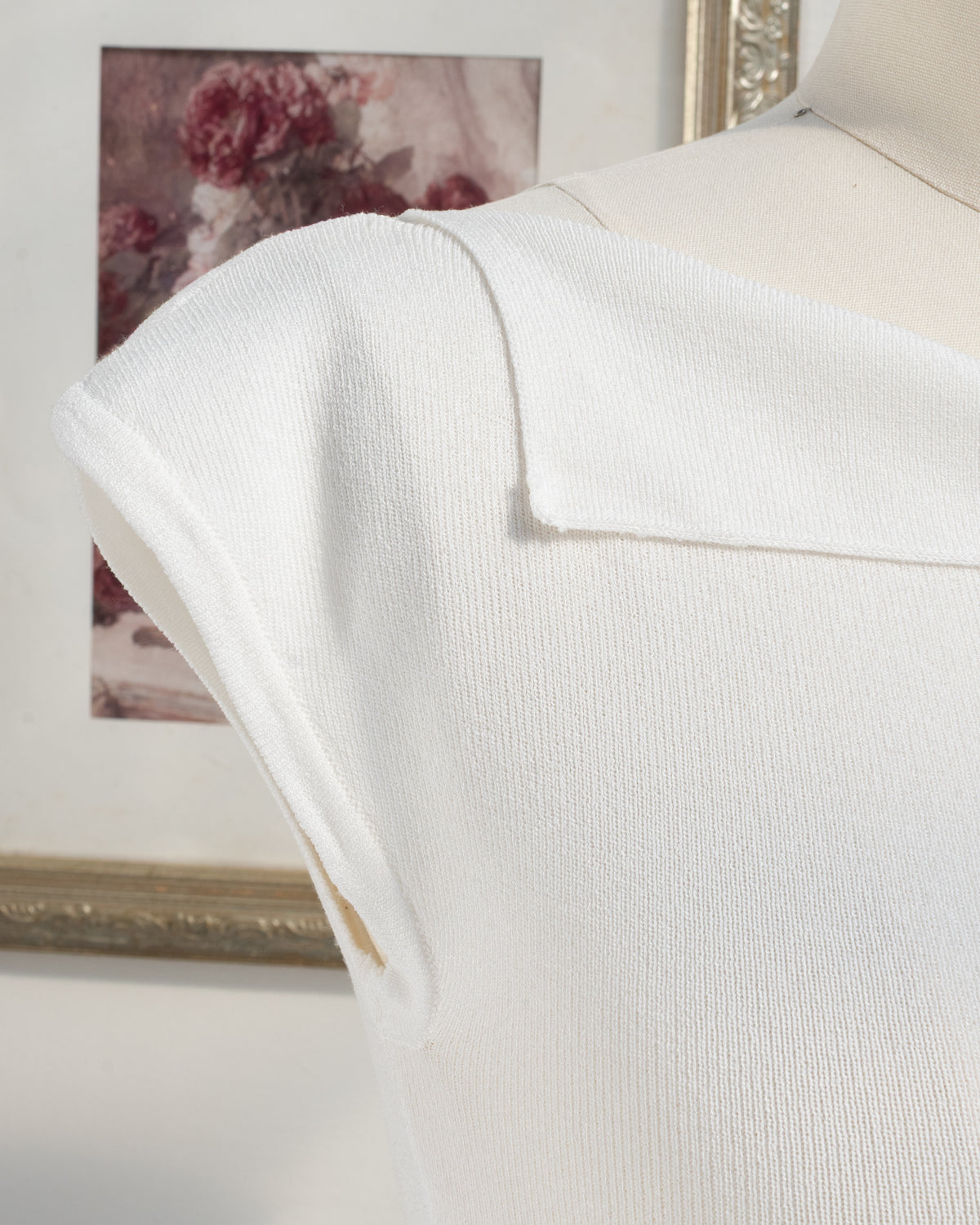 Ivory knit top with foldover boat neckline and structured cap sleeve, shoulder detail view.