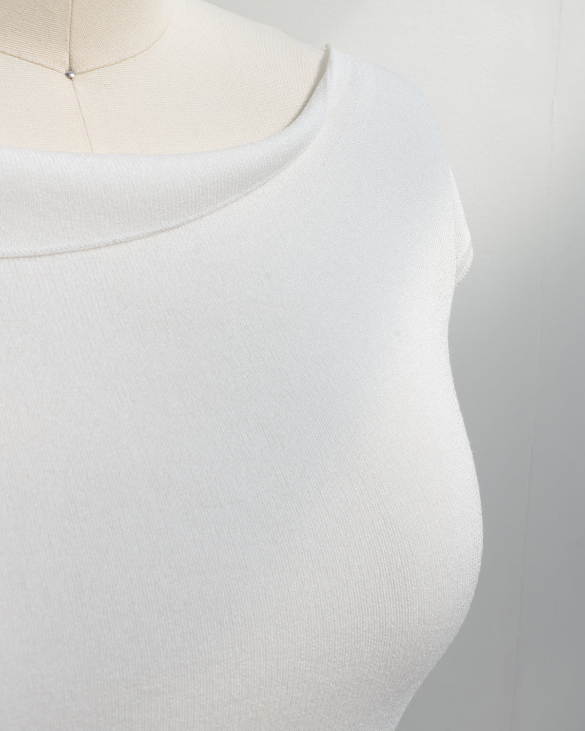 Ivory knit top with raw edge boat neckline, close up neckline detail view.