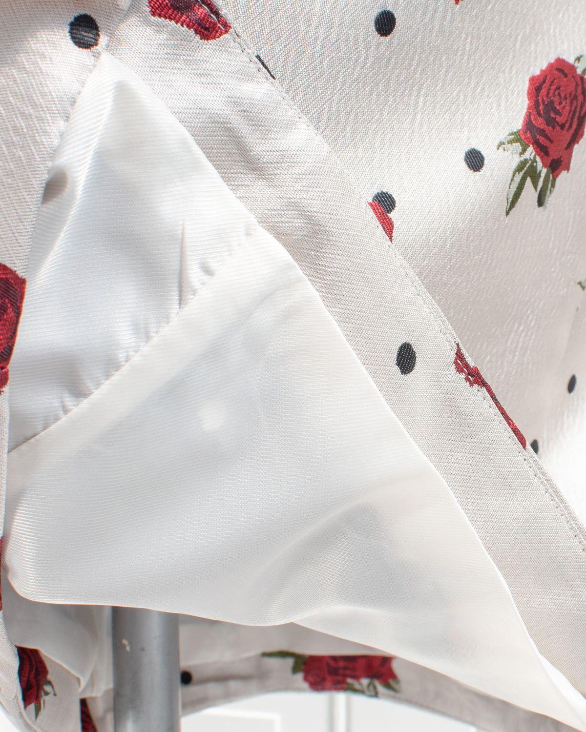 White interior lining of an ivory rose and polka dot mini dress, lining detail view.