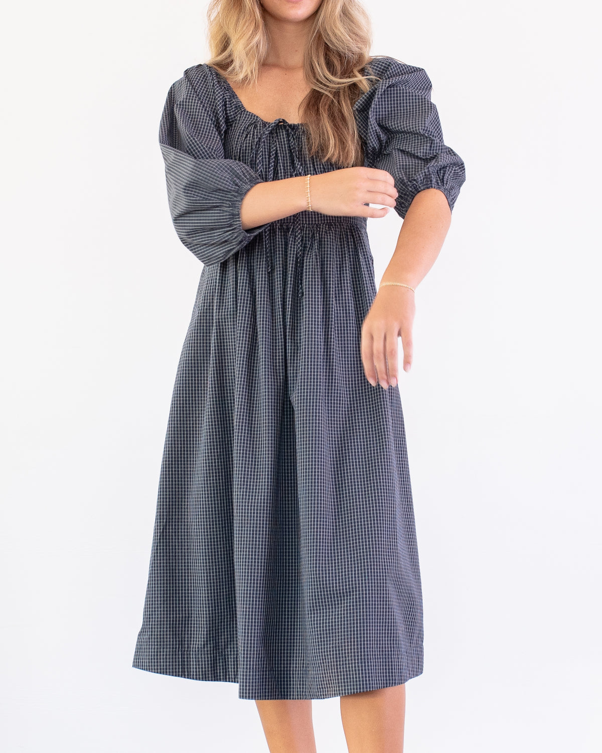 Navy check cotton midi dress with balloon sleeves and gathered skirt, a French girl style look, model front view.