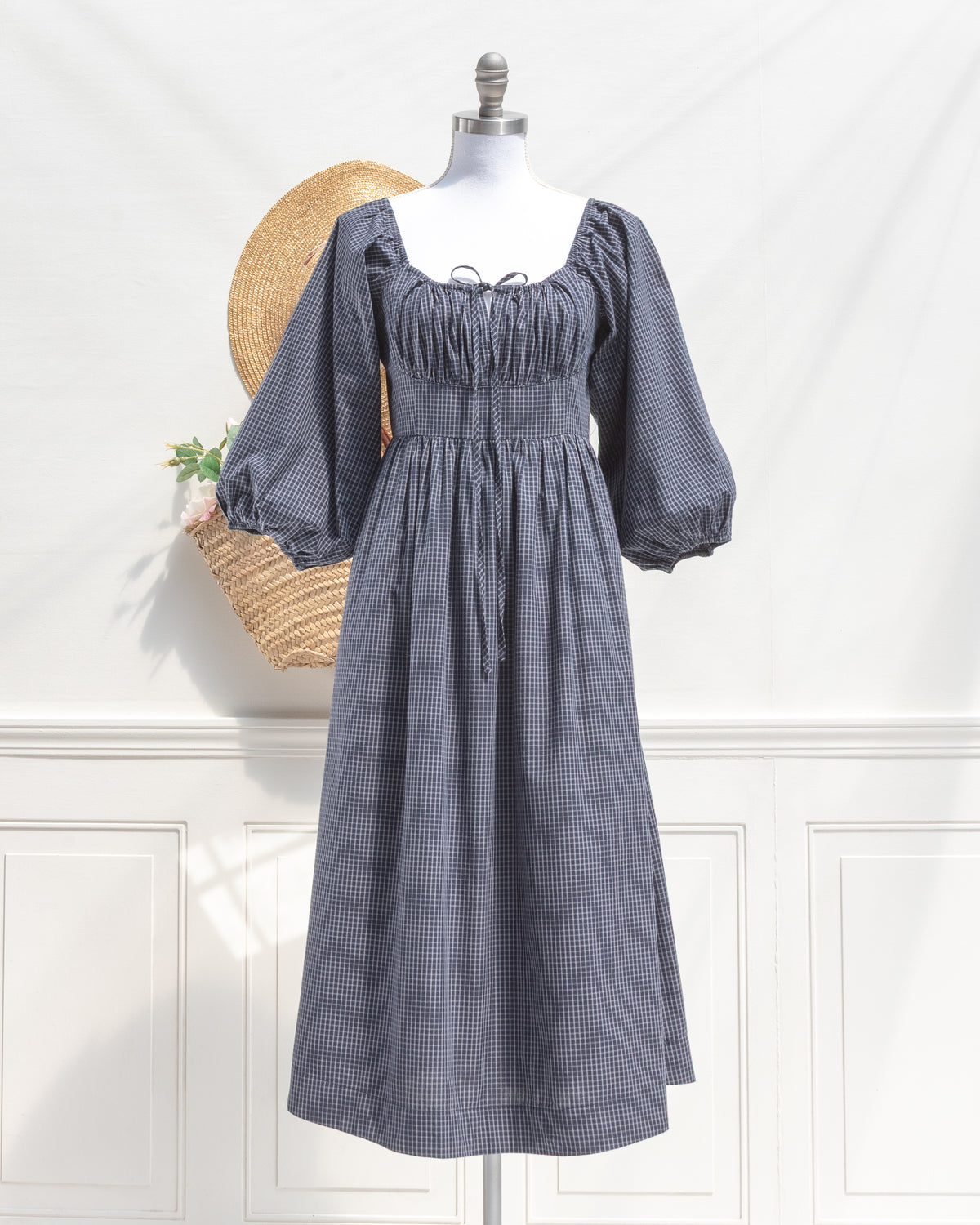 Navy check cotton midi dress with balloon sleeves and bust tie, a classic wardrobe staple, mannequin front view.