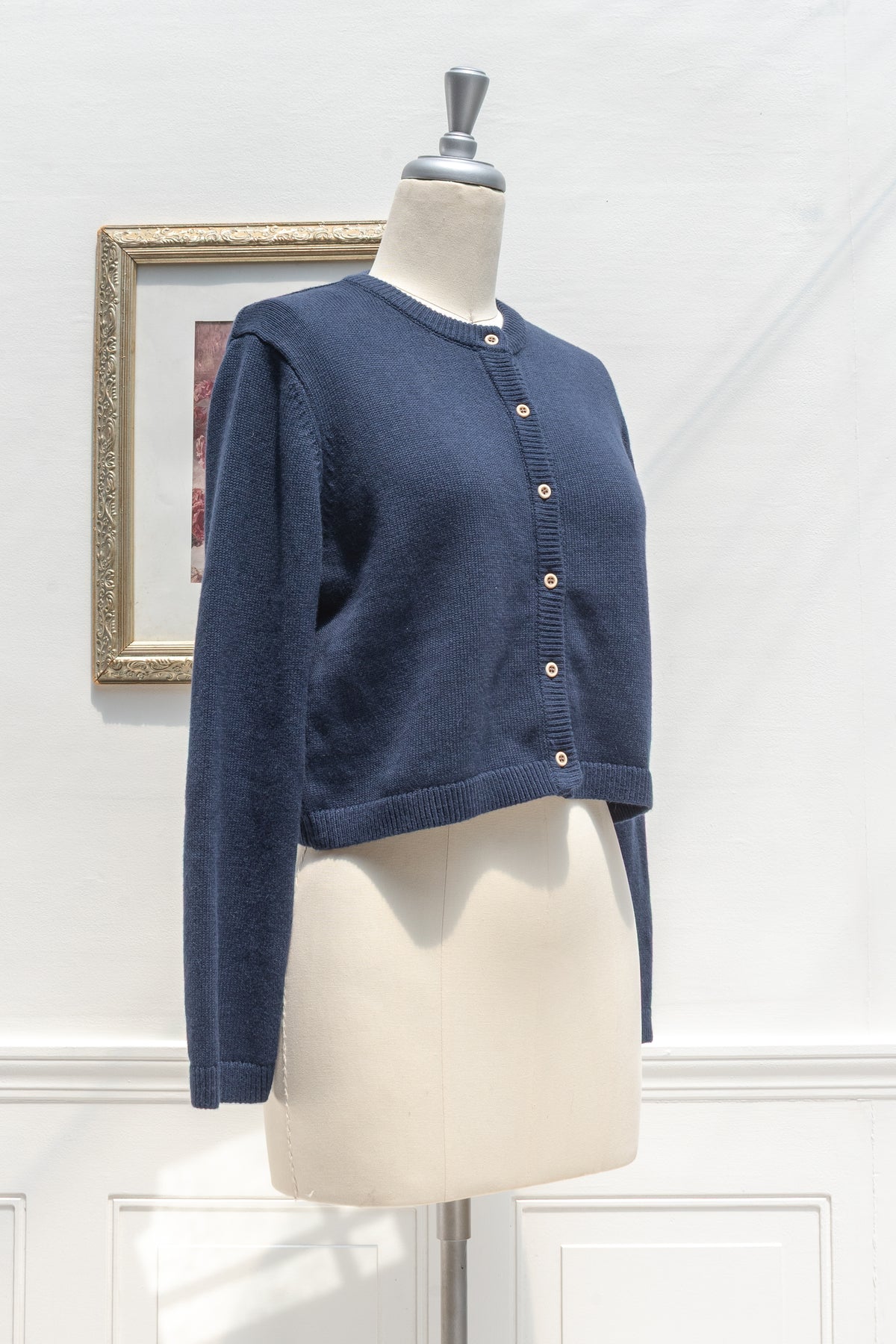 Navy cotton wool cropped cardigan displayed on a mannequin, three quarter view.