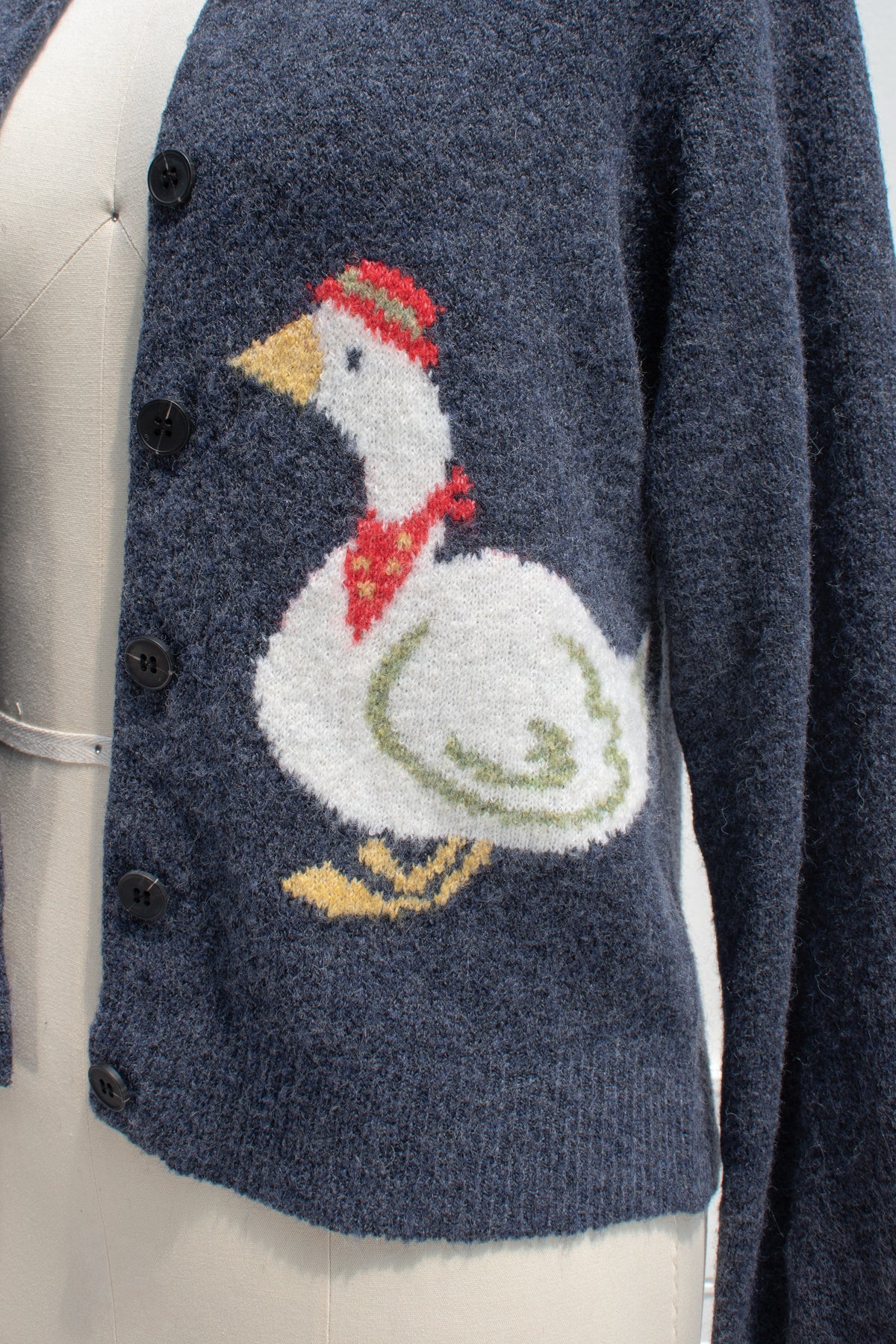 Detail of the goose motif on the navy knit cardigan.