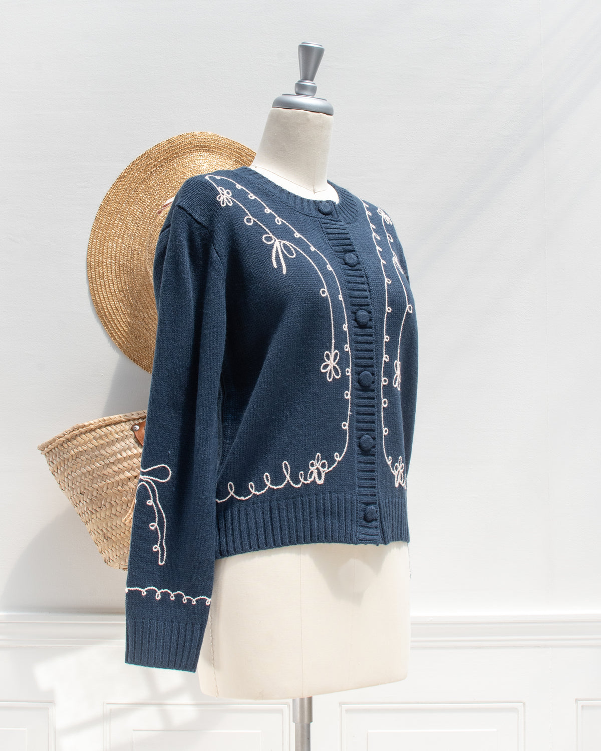 Feminine style cardigan. French girl style. Blue cardigan with whimsical bow detail embroidery. 3/4 view. Amantine