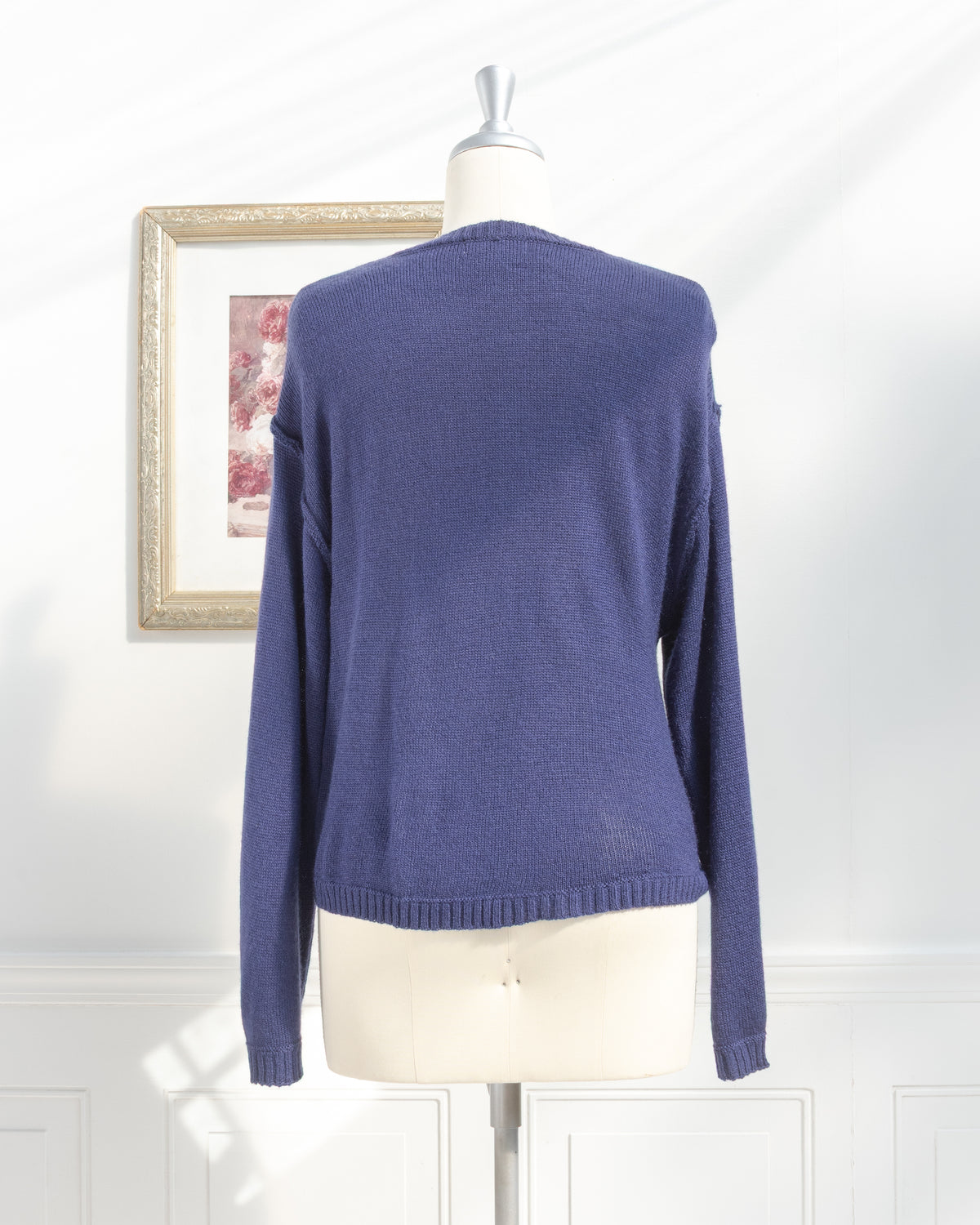 Navy knit sweater with ribbed hem and cuffs on a mannequin, back view.