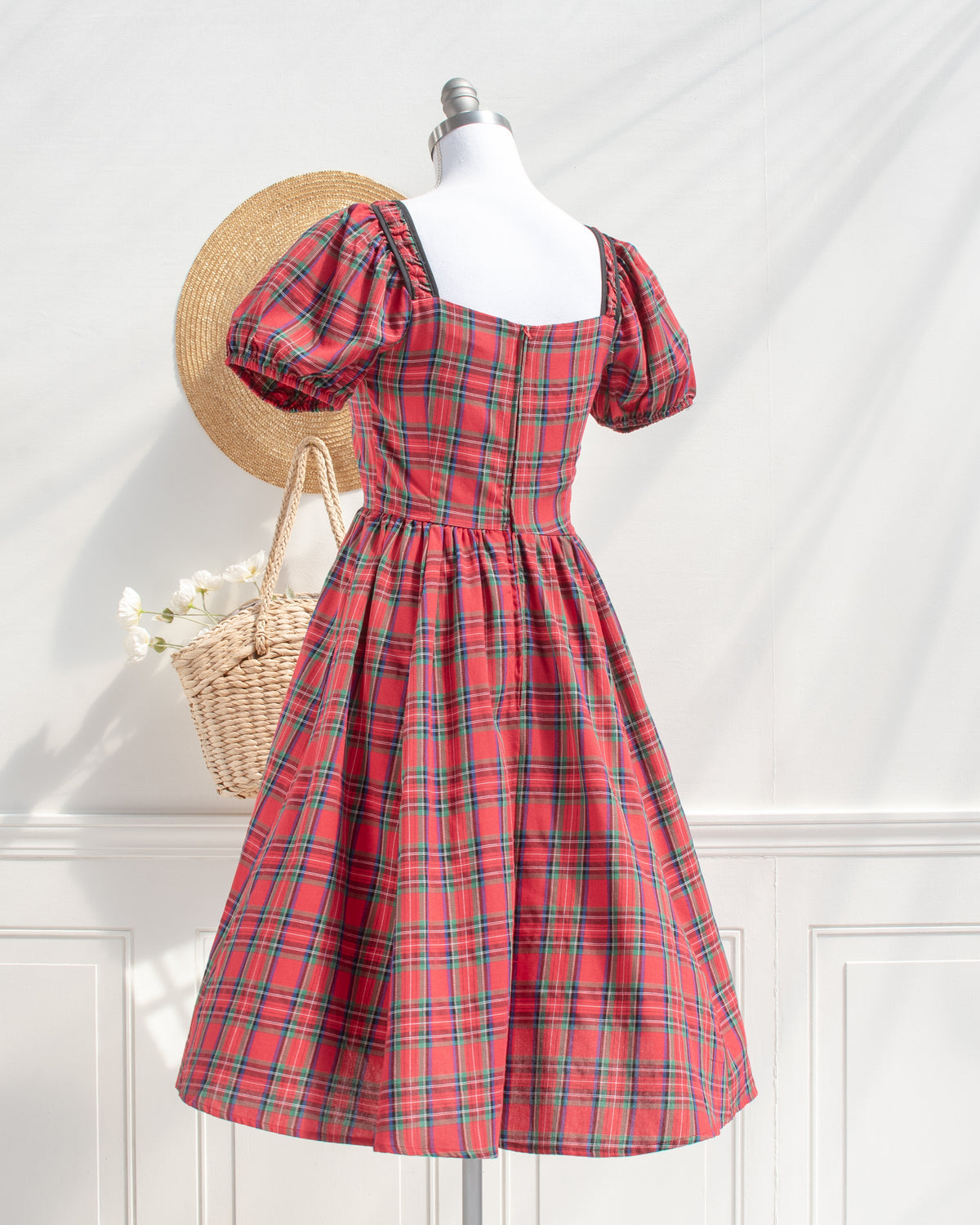 Feminine red plaid cotton midi dress with puff sleeves and a back zipper, styled on a mannequin, back view.