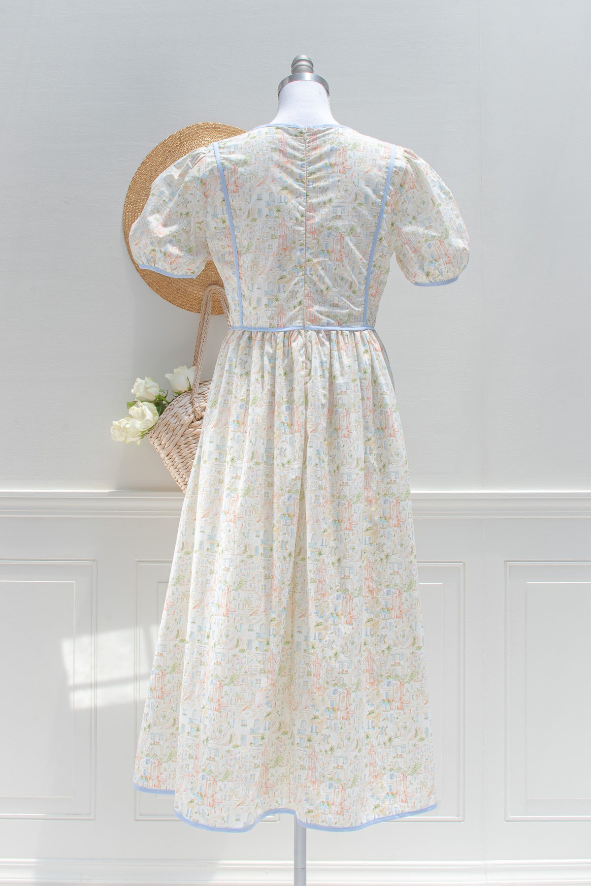 Toile print cotton midi dress showing back silhouette and blue trim seams on mannequin, back view.