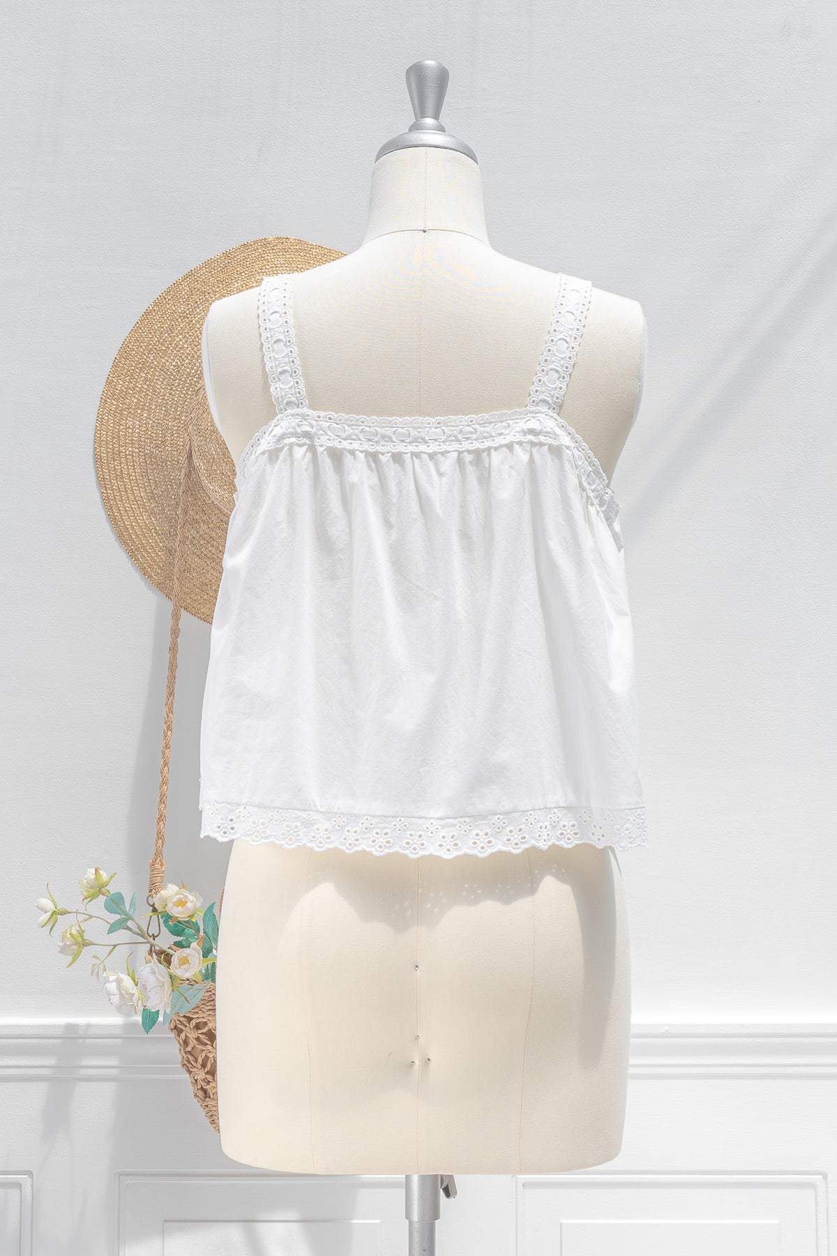White cotton chemise top showing eyelet strap detail and gathered back with scalloped hem, back view.