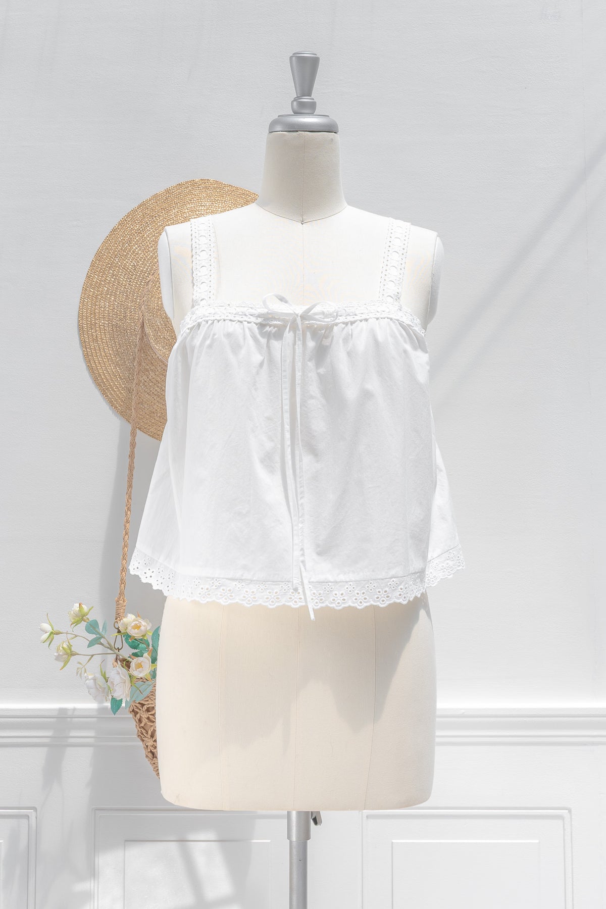 White cotton chemise top with eyelet hem trim, ribbon drawstring neckline and relaxed babydoll fit, front view.