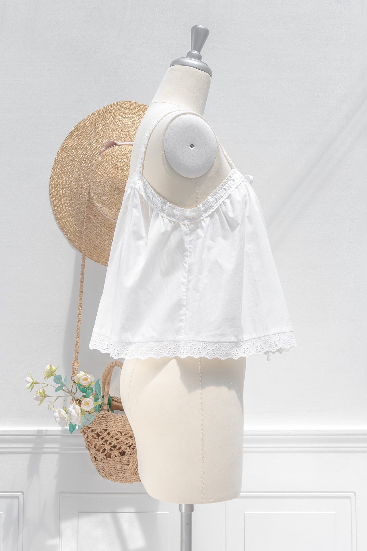 White cotton chemise top showing relaxed babydoll silhouette and eyelet scalloped hem, side view.