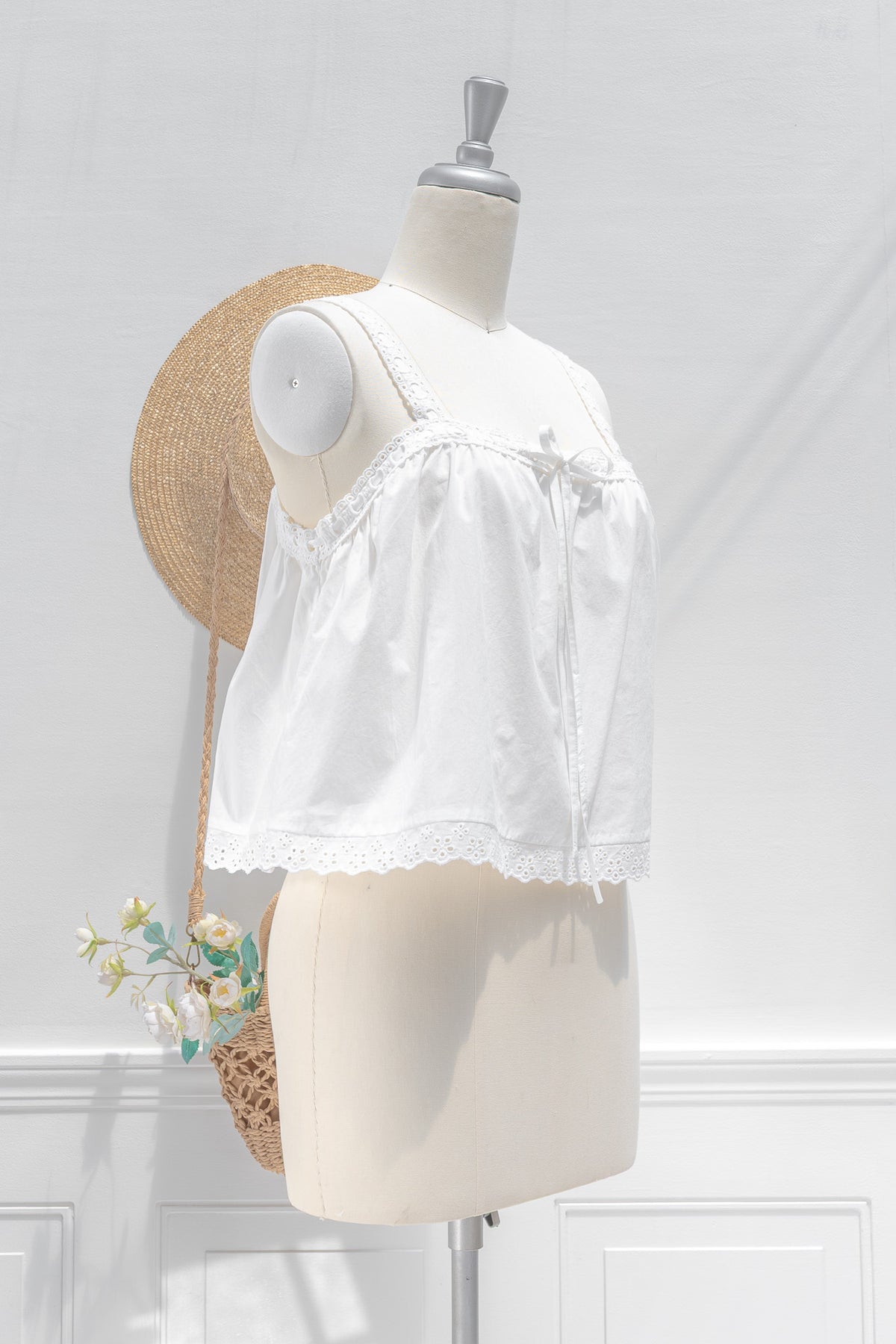 White cotton chemise top showing ribbon drawstring neckline and cropped babydoll length, three quarter view.