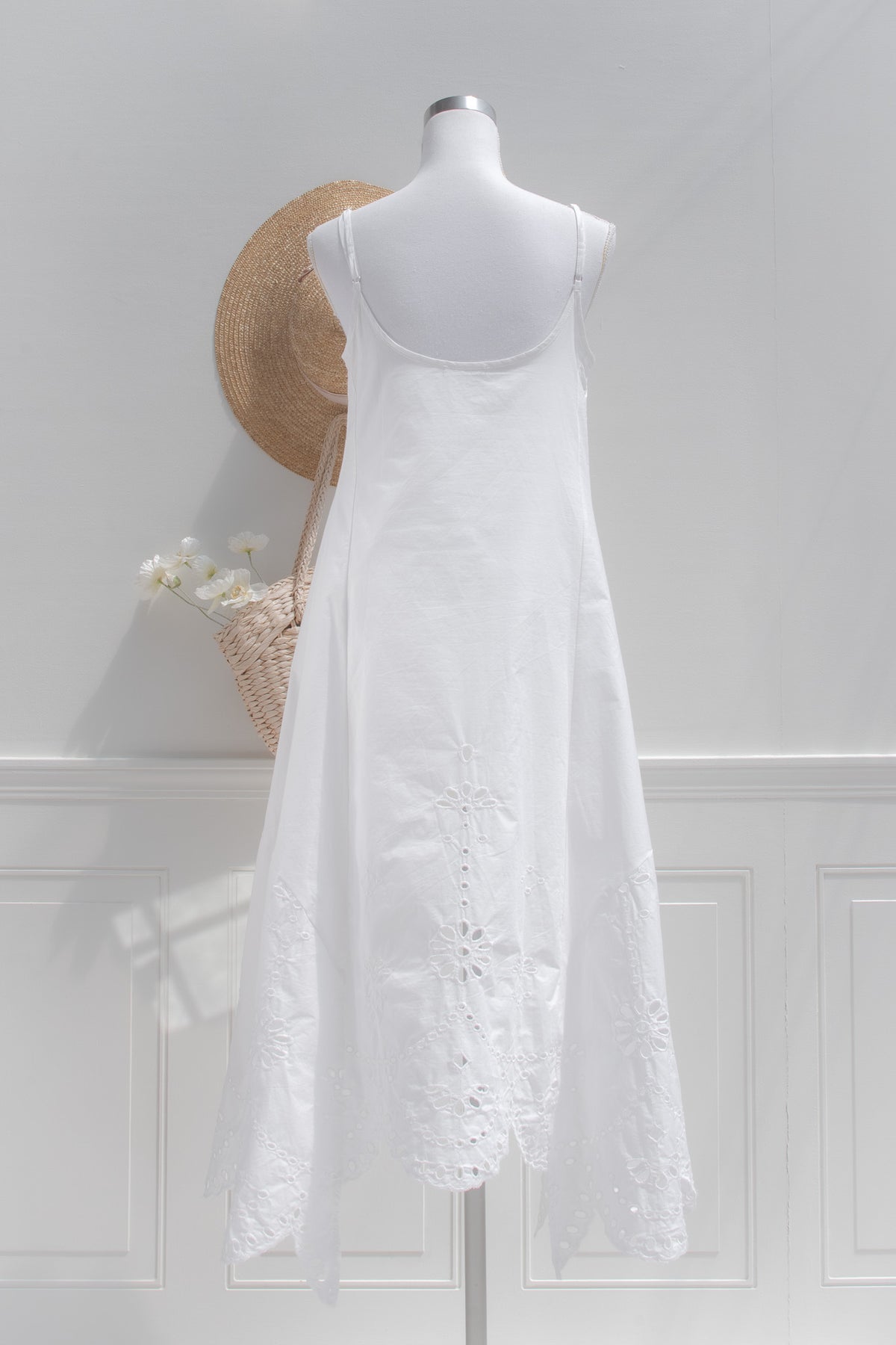 White cotton eyelet midi dress with adjustable spaghetti straps back view.