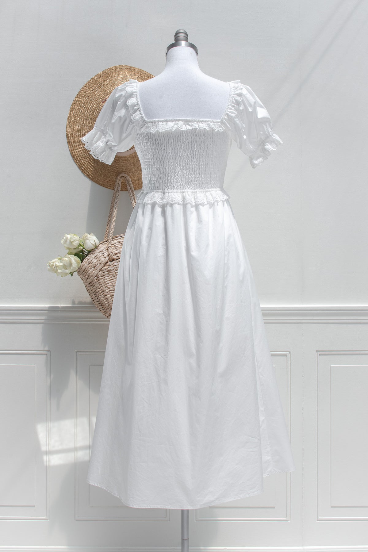 White cotton midi dress with square smocked back and eyelet lace trim, back view.
