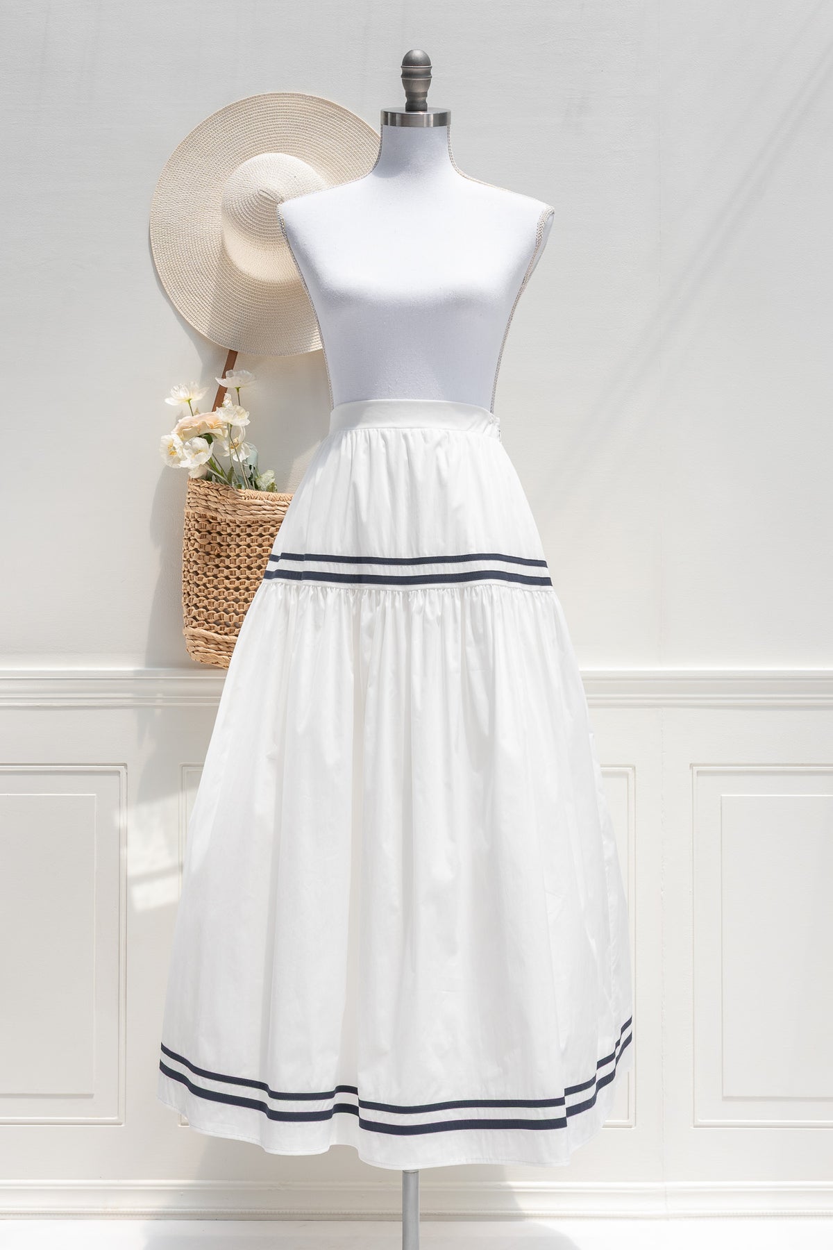 White cotton tiered midi skirt with navy stripe detail at tier seam and hem, front view.