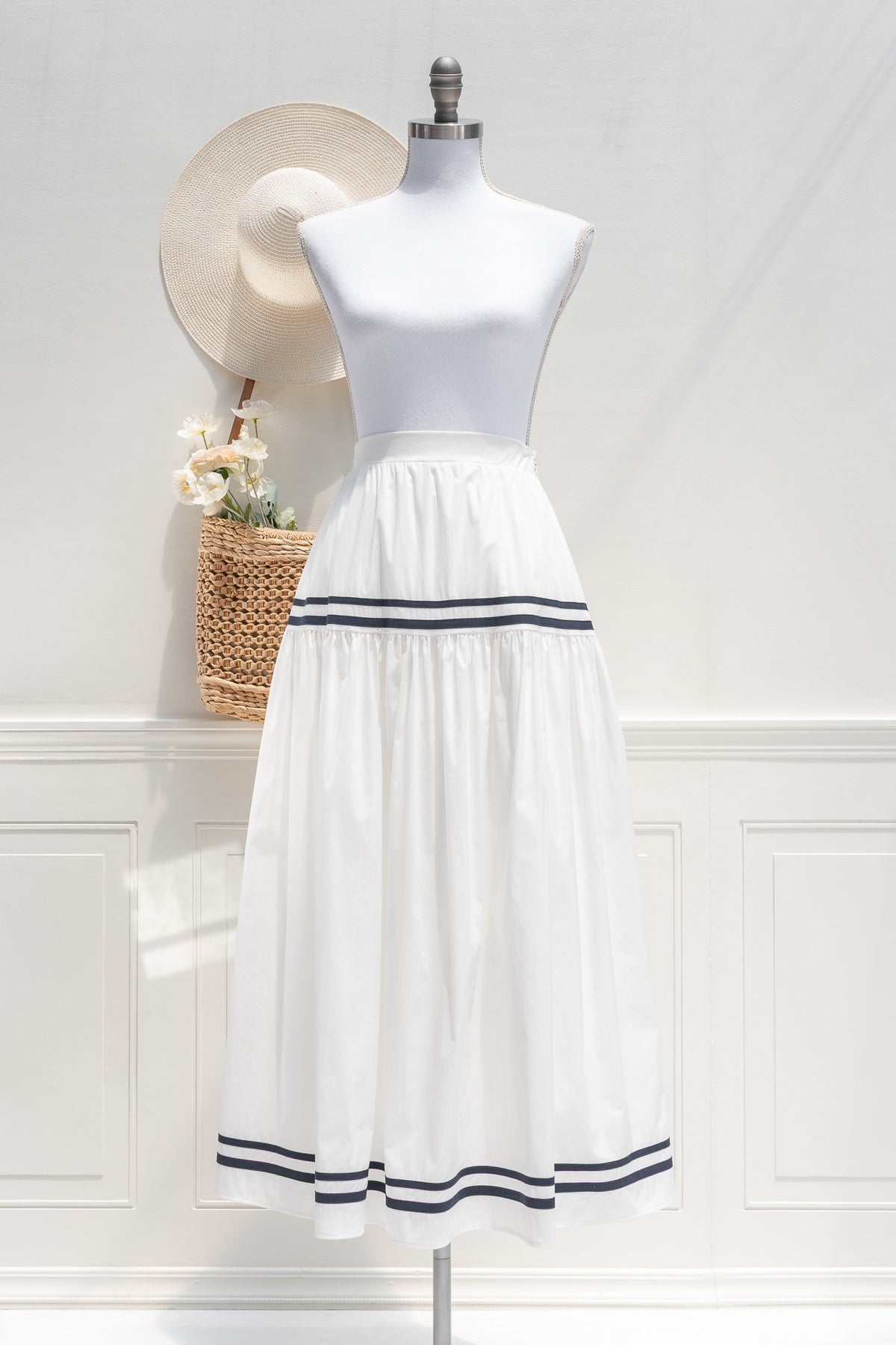 White cotton midi skirt with double navy stripe trim and tiered hem, front view.